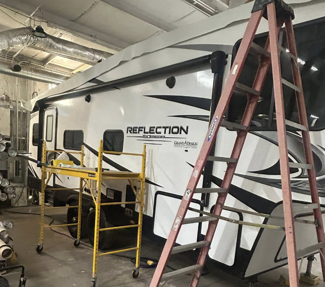 Camper in the repair shop set up for roof and exterior service work