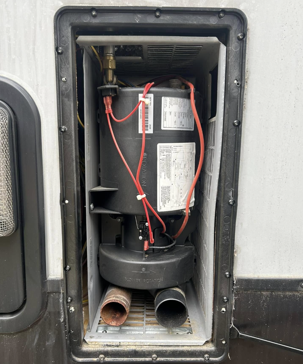 RV furnace compartment opened for service and heating system repair
