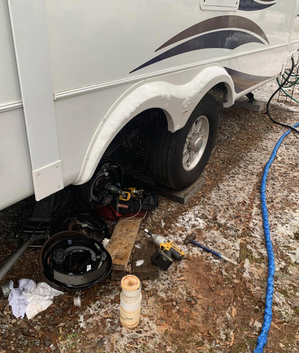 RV brake and wheel hub repair in progress on a travel trailer